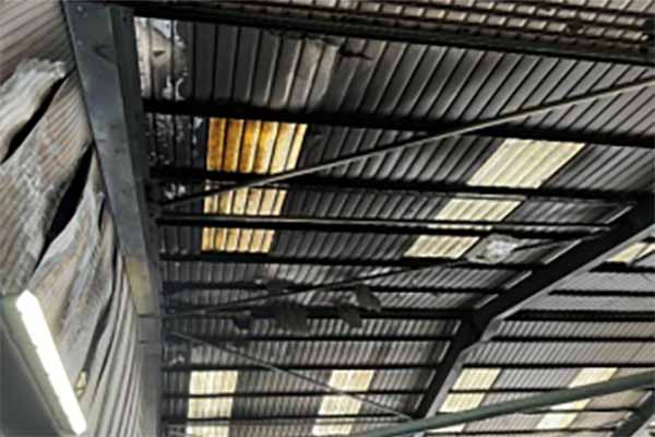 Corrugated roof with damaged walls and roof needing Building Reinstatement Cost Assessment 